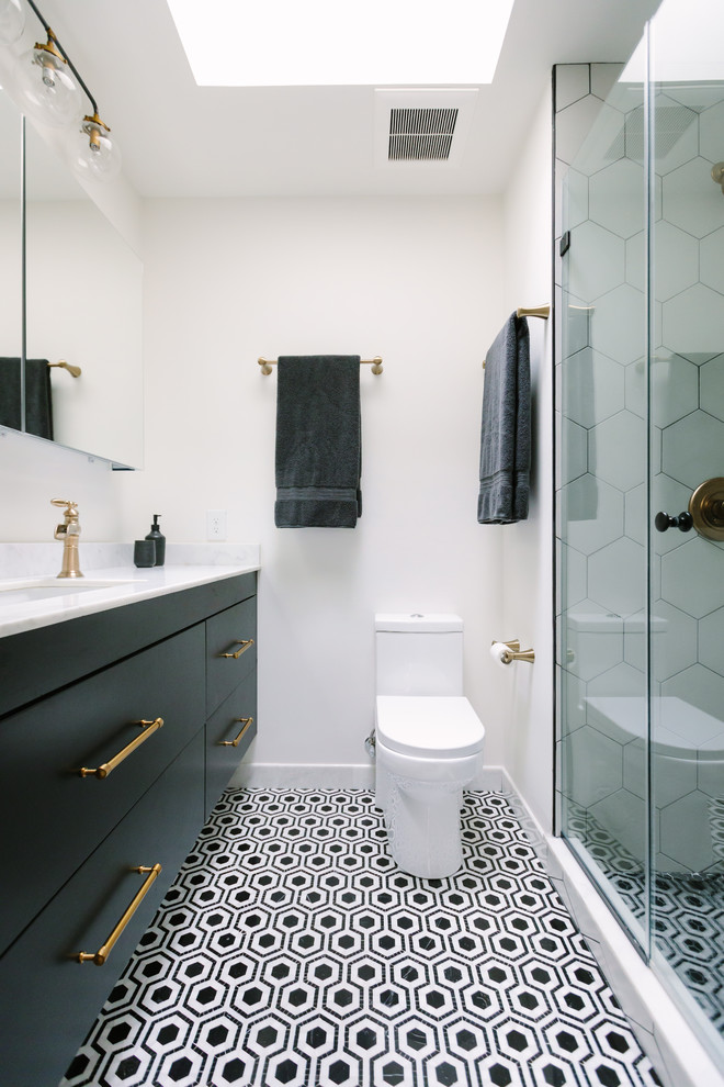 Modernes Badezimmer mit flächenbündigen Schrankfronten, schwarzen Schränken, Duschnische, weißen Fliesen, weißer Wandfarbe, Unterbauwaschbecken, buntem Boden und weißer Waschtischplatte