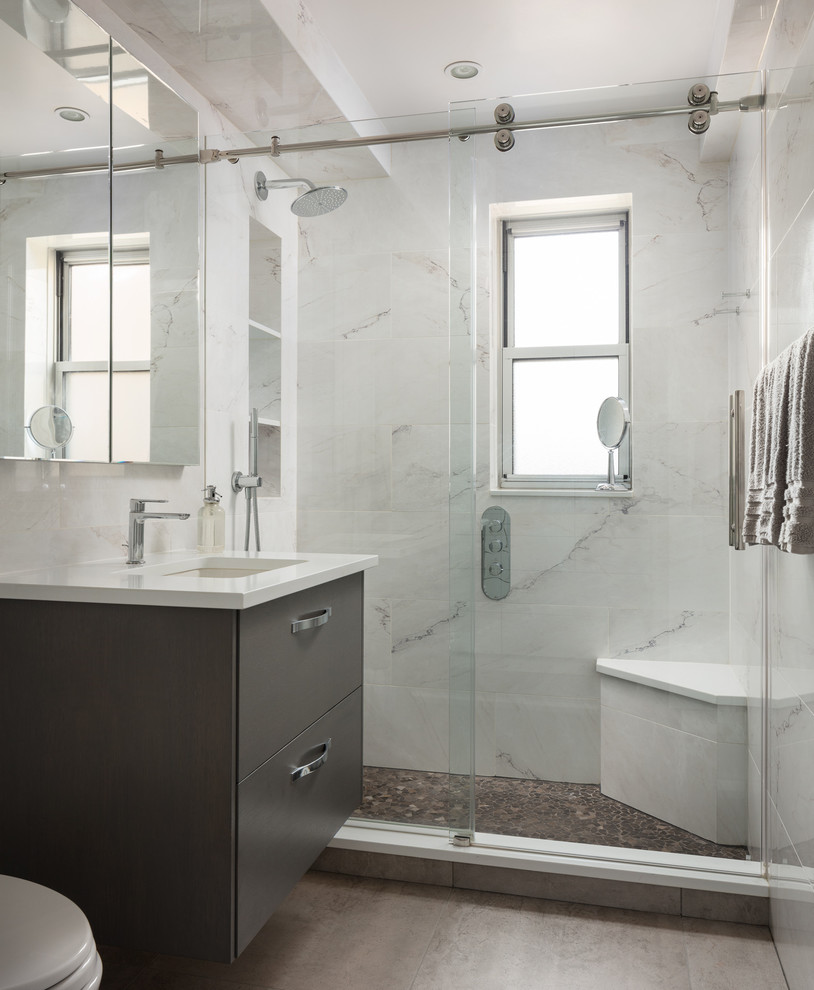 Example of a mid-sized minimalist 3/4 gray tile, white tile and stone tile porcelain tile and brown floor bathroom design in New York with flat-panel cabinets, gray cabinets, multicolored walls, an undermount sink, quartz countertops and white countertops