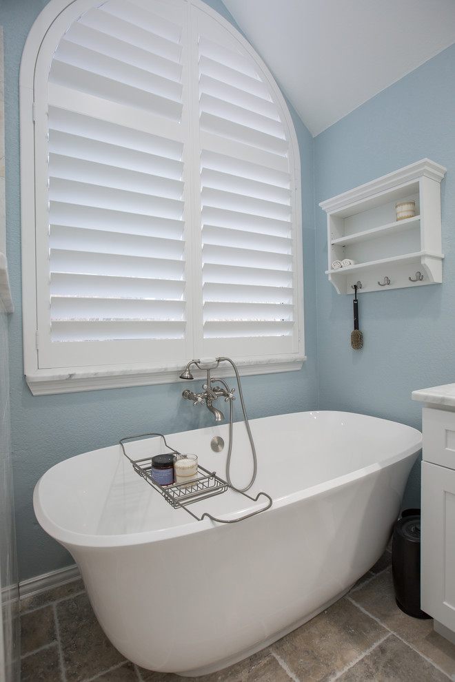 Пример оригинального дизайна: большая главная ванная комната в морском стиле с фасадами в стиле шейкер, белыми фасадами, отдельно стоящей ванной, угловым душем, серой плиткой, керамогранитной плиткой, синими стенами, полом из керамической плитки, врезной раковиной, мраморной столешницей, бежевым полом, душем с распашными дверями и белой столешницей