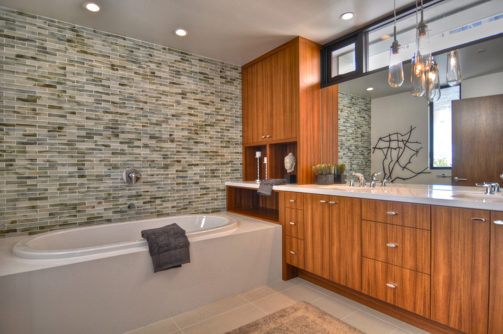 Inspiration för moderna badrum, med ett undermonterad handfat, släta luckor, skåp i mellenmörkt trä, ett platsbyggt badkar, flerfärgad kakel och mosaik