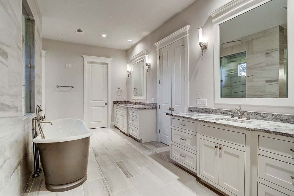 Bild på ett stort amerikanskt en-suite badrum, med luckor med lamellpanel, vita skåp, ett fristående badkar, våtrum, svart och vit kakel, stenkakel, grå väggar, klinkergolv i keramik, ett undermonterad handfat, marmorbänkskiva, flerfärgat golv och dusch med gångjärnsdörr