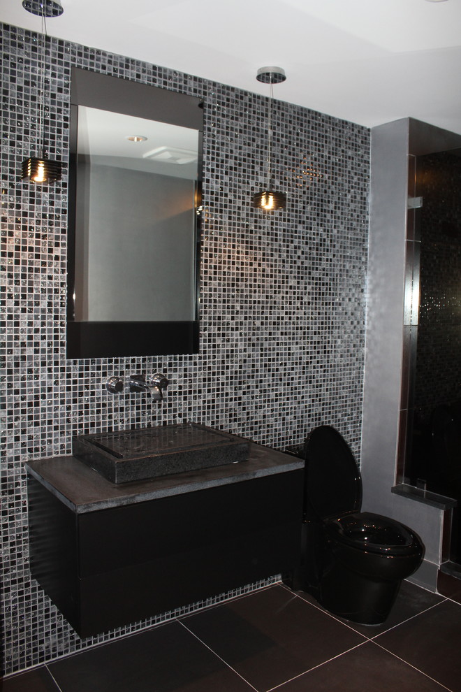 Diseño de cuarto de baño minimalista con armarios con rebordes decorativos, encimera de esteatita, baldosas y/o azulejos de vidrio y paredes negras