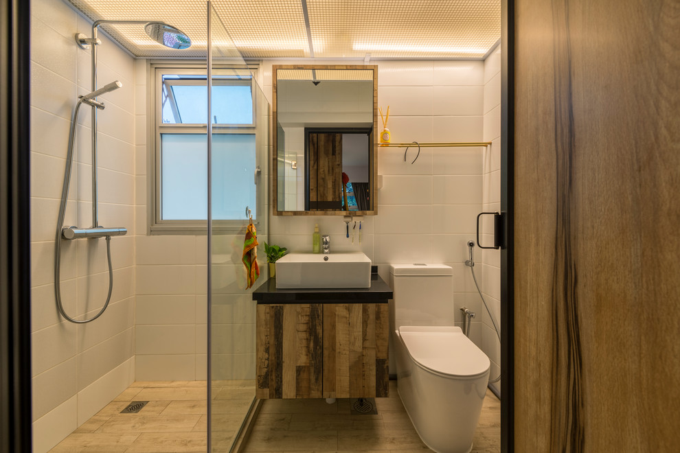 На фото: ванная комната в современном стиле с плоскими фасадами, фасадами цвета дерева среднего тона, угловым душем, унитазом-моноблоком, белой плиткой, душевой кабиной, настольной раковиной, коричневым полом и открытым душем с