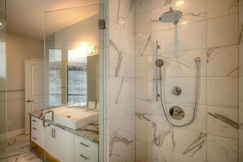 На фото: главная ванная комната среднего размера в стиле модернизм с плоскими фасадами, белыми фасадами, угловым душем, раздельным унитазом, серой плиткой, плиткой из листового камня, белыми стенами, мраморным полом, раковиной с несколькими смесителями и мраморной столешницей с