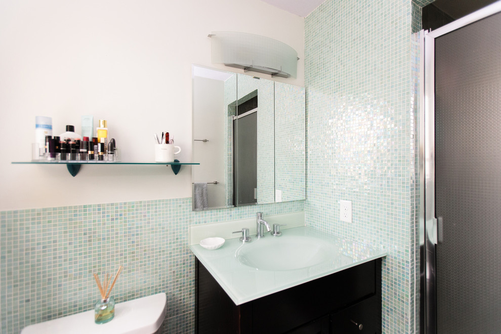 Réalisation d'une salle d'eau design de taille moyenne avec WC séparés, un carrelage vert, des plaques de verre, un mur blanc, un lavabo intégré et un plan de toilette en surface solide.
