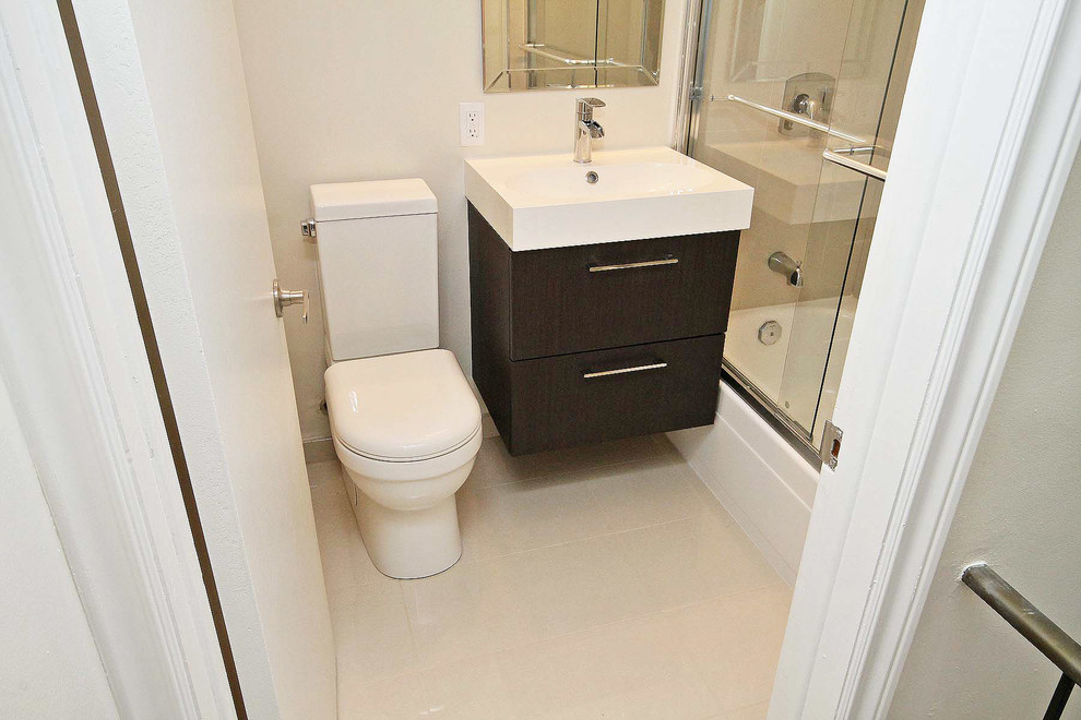 Modernes Badezimmer mit integriertem Waschbecken, flächenbündigen Schrankfronten, braunen Schränken, Mineralwerkstoff-Waschtisch, Badewanne in Nische, Duschbadewanne, Wandtoilette mit Spülkasten, beigen Fliesen und Porzellanfliesen in Ottawa