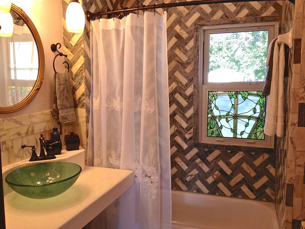 Klassisk inredning av ett mellanstort badrum, med ett fristående handfat, möbel-liknande, skåp i mörkt trä, granitbänkskiva, ett badkar i en alkov, en dusch/badkar-kombination, en toalettstol med separat cisternkåpa, grå kakel, vita väggar och klinkergolv i keramik