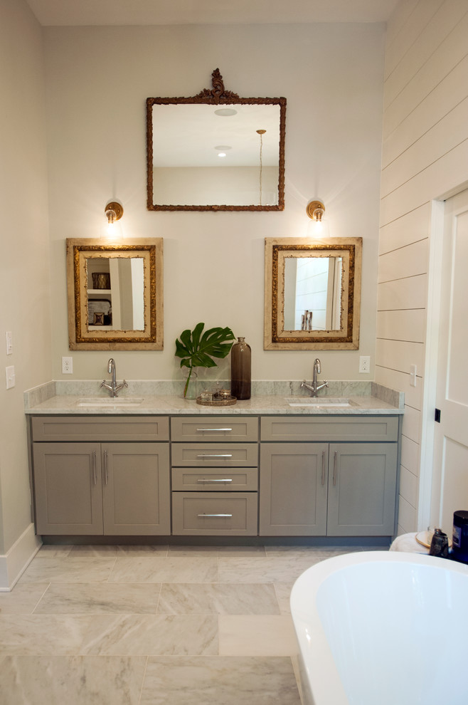Exemple d'une salle de bain principale éclectique de taille moyenne avec un placard à porte shaker, des portes de placard grises, une baignoire indépendante, un carrelage blanc, du carrelage en marbre, un mur blanc, un sol en marbre et un lavabo encastré.
