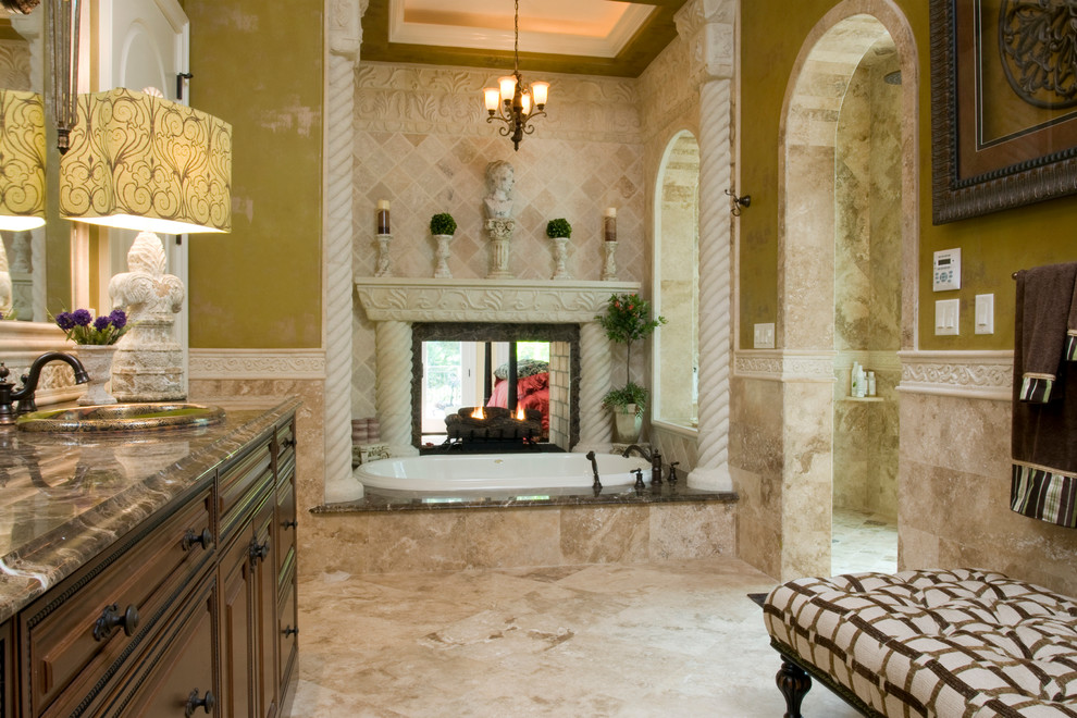 Example of a large tuscan master beige tile, brown tile and stone tile travertine floor bathroom design in Charleston with raised-panel cabinets, dark wood cabinets, a two-piece toilet, beige walls and a drop-in sink
