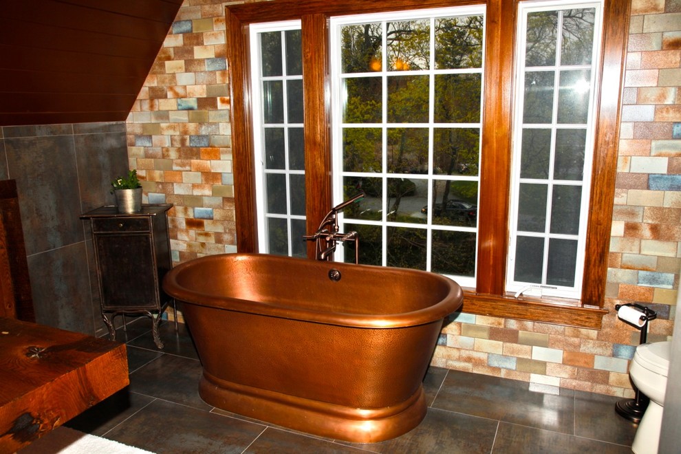 Exemple d'une salle de bain chic de taille moyenne avec une baignoire indépendante, WC séparés, un mur multicolore, un sol en carrelage de porcelaine, une vasque et un plan de toilette en bois.