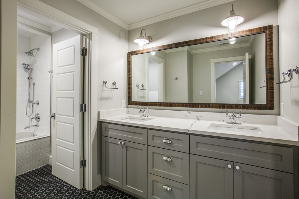 Photo of a medium sized traditional family bathroom in Dallas with shaker cabinets, grey cabinets, a built-in bath, a shower/bath combination, a two-piece toilet, black tiles, ceramic tiles, grey walls, mosaic tile flooring, a submerged sink and engineered stone worktops.
