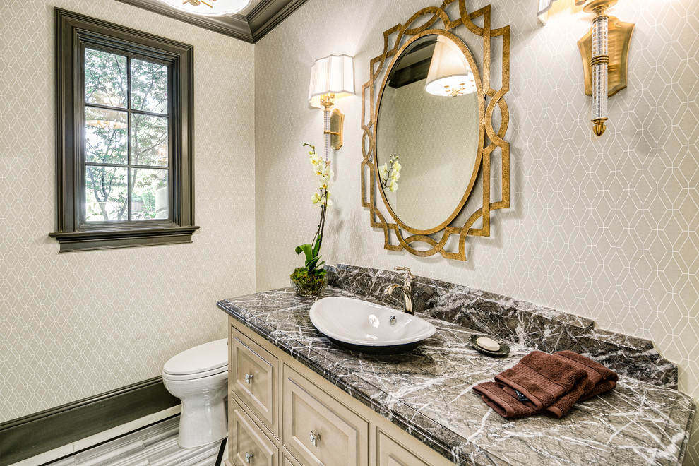 Example of a transitional marble floor bathroom design in Los Angeles with raised-panel cabinets, beige cabinets, beige walls, a vessel sink, marble countertops and black countertops