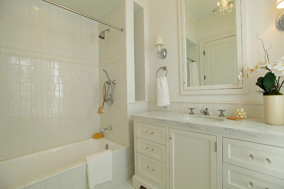 Источник вдохновения для домашнего уюта: ванная комната в классическом стиле с врезной раковиной, фасадами с утопленной филенкой, белыми фасадами, ванной в нише, душем над ванной и белой плиткой