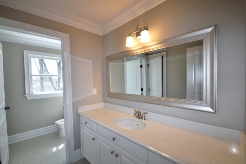 Idéer för mellanstora funkis en-suite badrum, med luckor med infälld panel, vita skåp, en toalettstol med hel cisternkåpa, grå väggar, klinkergolv i keramik, ett undermonterad handfat och bänkskiva i akrylsten