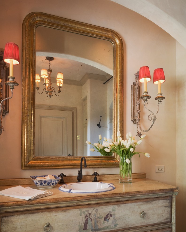 На фото: ванная комната в средиземноморском стиле с накладной раковиной, искусственно-состаренными фасадами и плоскими фасадами с