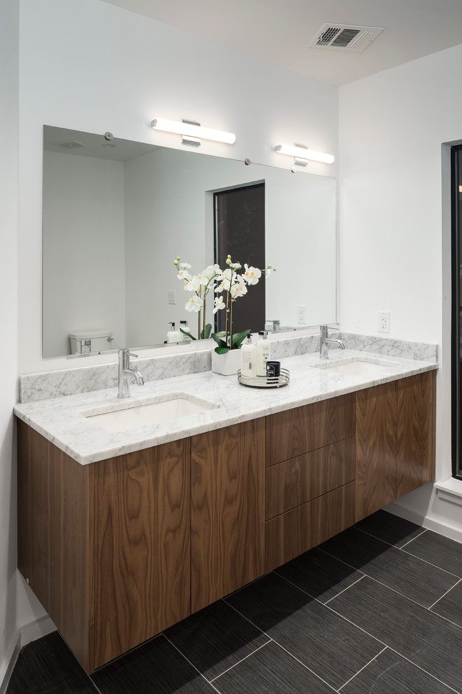 This is an example of a small modern ensuite bathroom in Austin with flat-panel cabinets, dark wood cabinets, a one-piece toilet, white tiles, white walls, marble worktops, grey floors, grey worktops, a single sink, a floating vanity unit, a drop ceiling, ceramic flooring and a submerged sink.