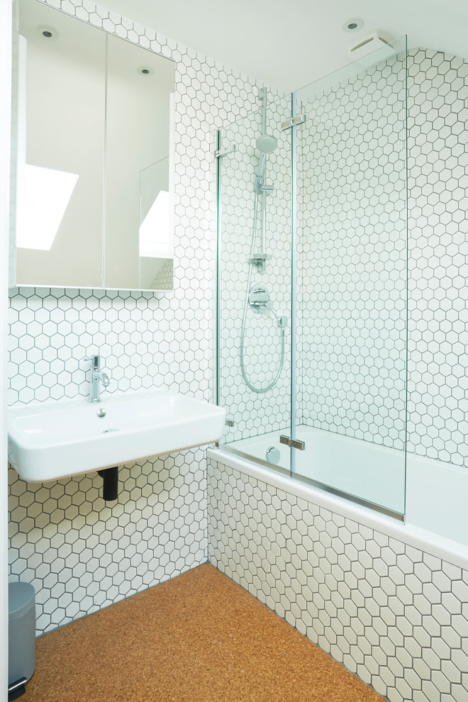 Minimalistisk inredning av ett badrum för barn, med ett platsbyggt badkar, vit kakel och ett väggmonterat handfat