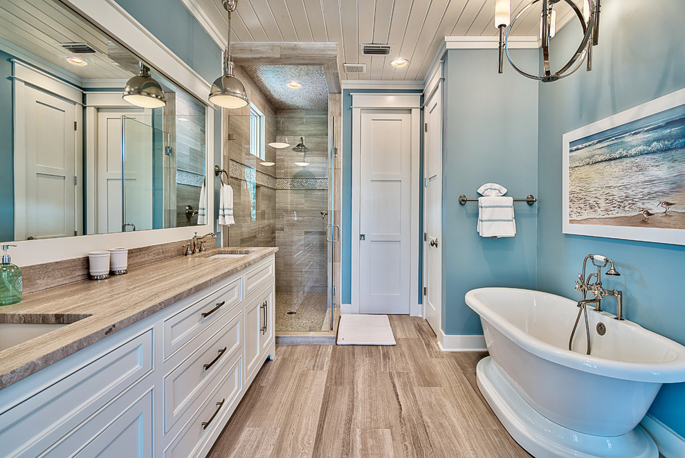 マイアミにあるビーチスタイルのおしゃれな浴室 (落し込みパネル扉のキャビネット、グレーのキャビネット、置き型浴槽) の写真