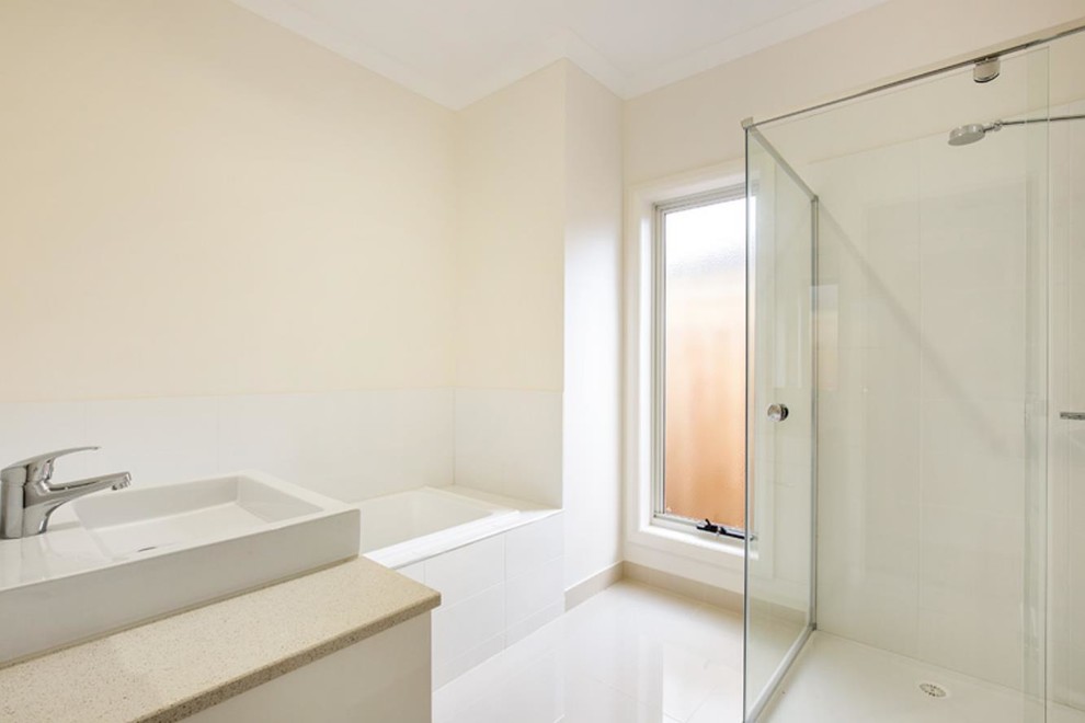 Inspiration for a medium sized contemporary family bathroom in Melbourne with flat-panel cabinets, white cabinets, a built-in bath, a walk-in shower, white tiles, ceramic tiles, beige walls, ceramic flooring, an integrated sink, engineered stone worktops, white floors and an open shower.