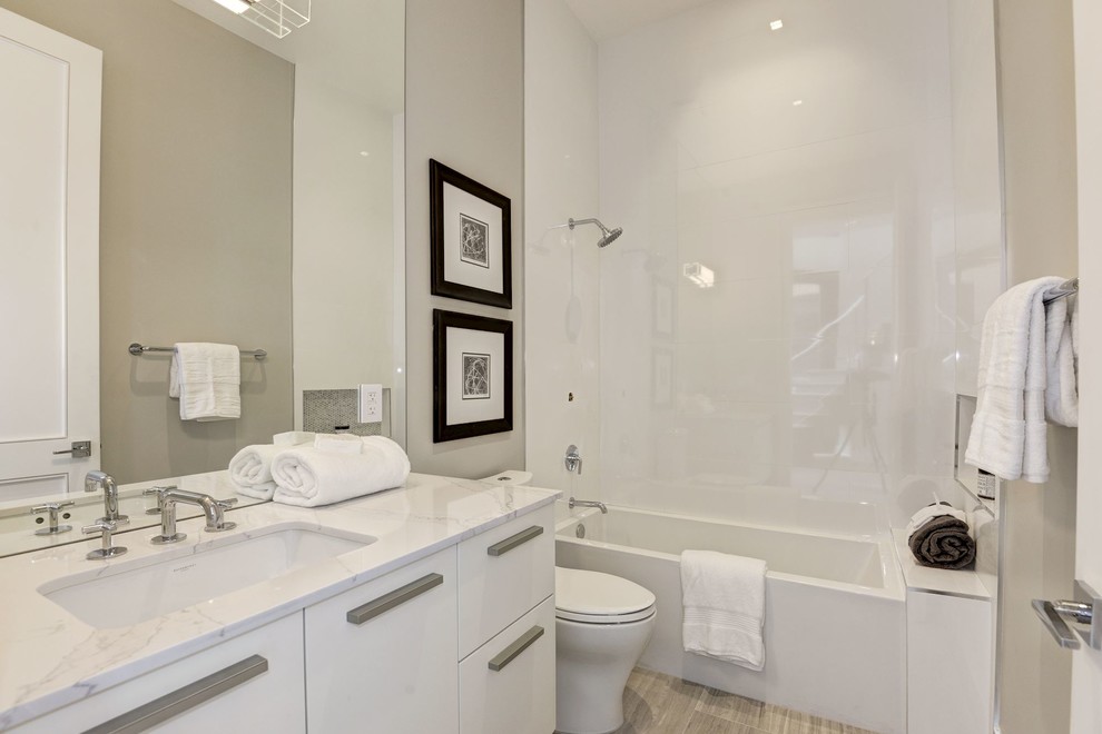 Ispirazione per una stanza da bagno design con ante lisce, ante bianche, doccia ad angolo, pareti grigie, lavabo sottopiano, top in quarzo composito e pavimento grigio