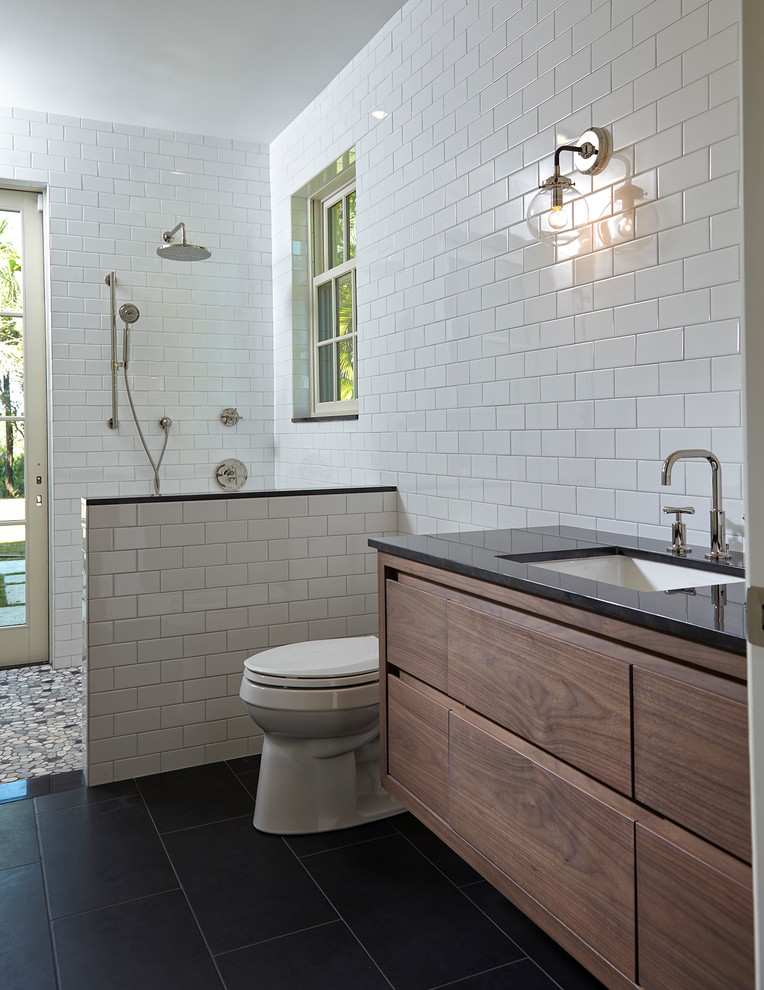 Идея дизайна: главная ванная комната среднего размера с фасадами с филенкой типа жалюзи, черными фасадами, отдельно стоящей ванной, открытым душем, унитазом-моноблоком, белой плиткой, керамической плиткой, белыми стенами, полом из керамической плитки, накладной раковиной, мраморной столешницей, черным полом и открытым душем