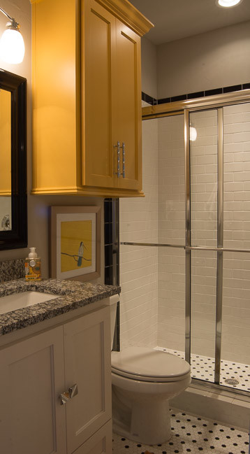 Inredning av ett eklektiskt stort en-suite badrum, med gula skåp, granitbänkskiva, ett platsbyggt badkar, en öppen dusch, en toalettstol med hel cisternkåpa, grå väggar, klinkergolv i keramik, luckor med infälld panel, svart och vit kakel, keramikplattor, ett undermonterad handfat, grått golv och dusch med skjutdörr