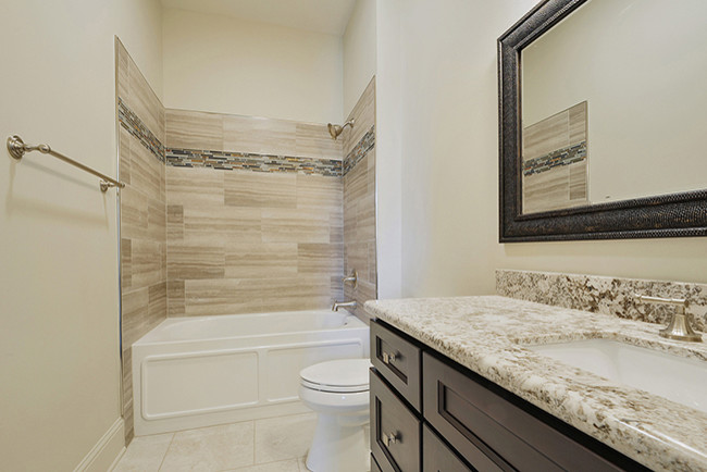 Example of a large classic kids' beige tile and ceramic tile ceramic tile bathroom design in New Orleans with an undermount sink, raised-panel cabinets, dark wood cabinets, granite countertops, a one-piece toilet and white walls