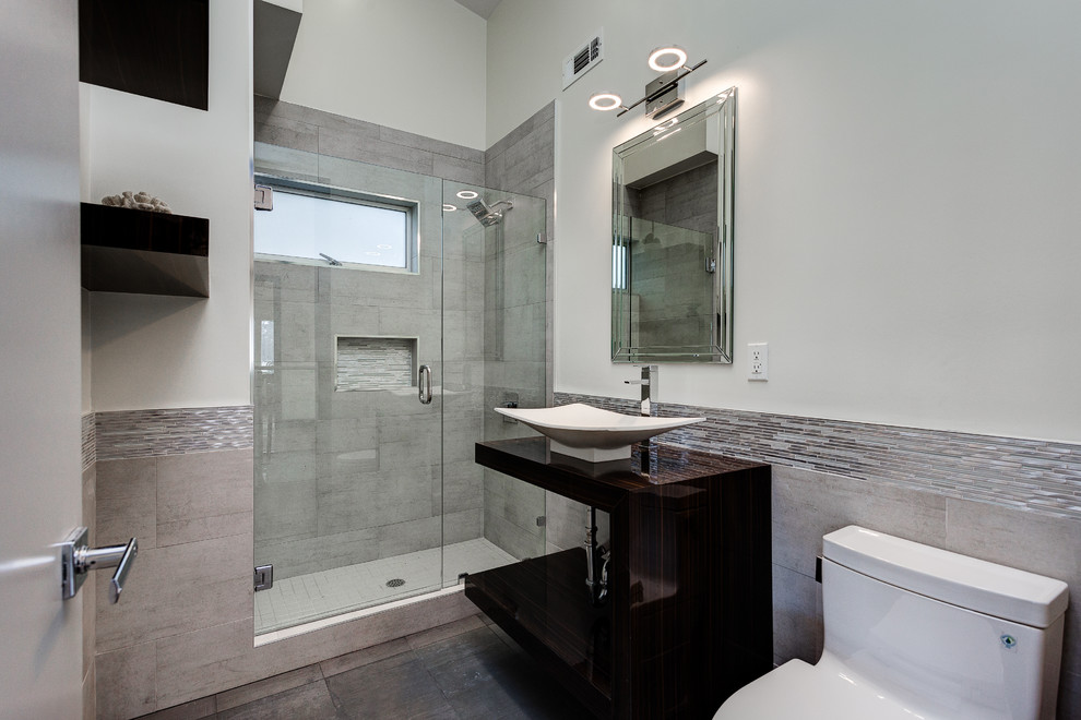 Exemple d'une grande salle de bain moderne avec WC à poser, un carrelage gris, un carrelage en pâte de verre, un mur blanc, un sol en carrelage de céramique et une vasque.