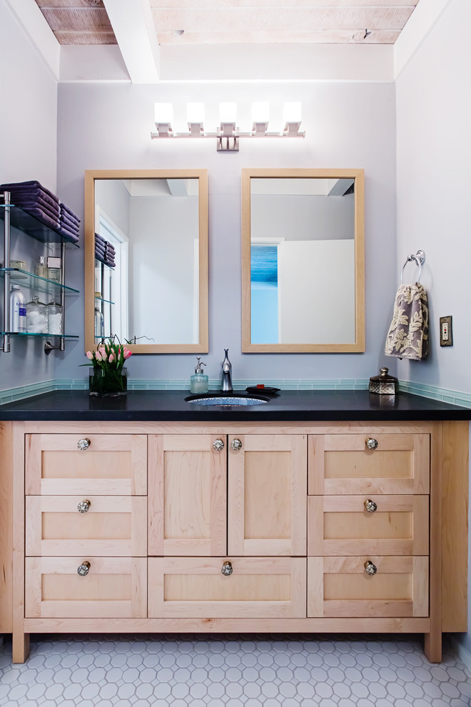 Cette image montre une salle de bain design en bois clair avec un lavabo encastré, un placard à porte shaker, un carrelage bleu et des carreaux en allumettes.