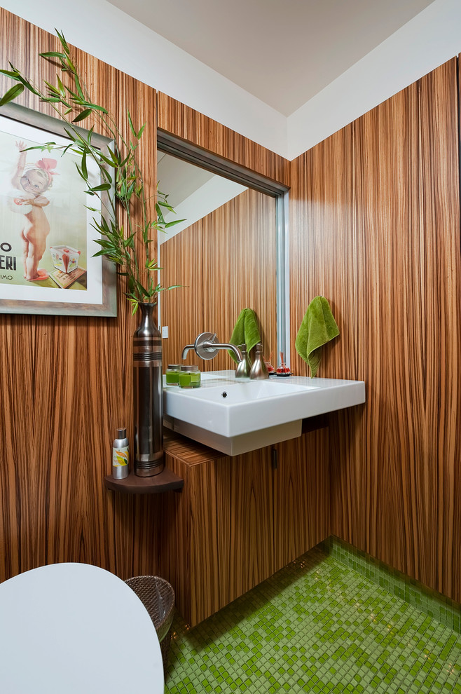 Exempel på ett retro badrum, med mosaikgolv, bruna väggar, ett väggmonterat handfat, glaskakel, grön kakel, skåp i mellenmörkt trä, släta luckor och grönt golv