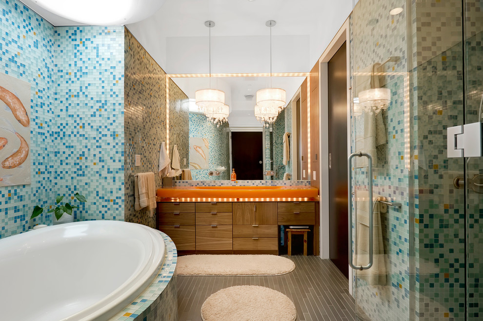 Foto på ett funkis en-suite badrum, med släta luckor, skåp i mellenmörkt trä, flerfärgad kakel, ett platsbyggt badkar, ett integrerad handfat och blå väggar