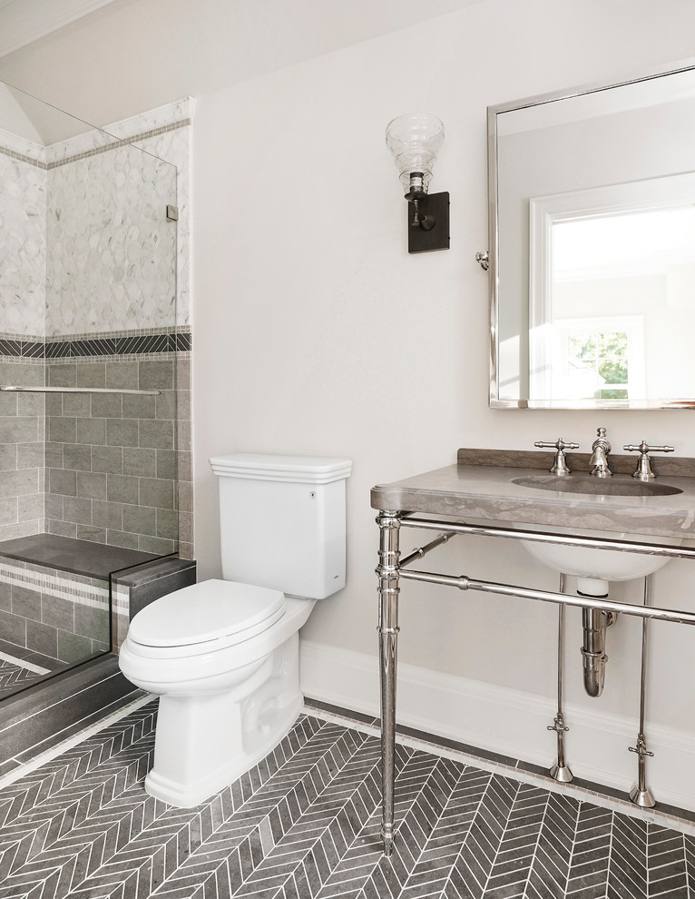 This is an example of a medium sized traditional bathroom in New York with a two-piece toilet, white tiles, grey tiles, stone tiles, beige walls, limestone flooring, marble worktops, an alcove shower and a console sink.