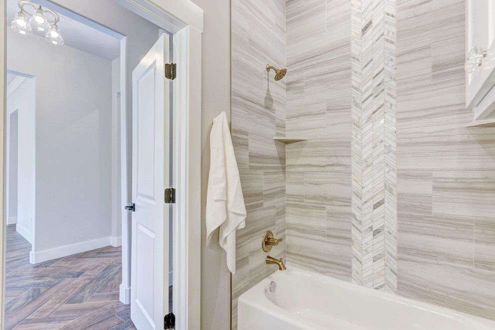 Bild på ett stort lantligt flerfärgad flerfärgat badrum, med skåp i shakerstil, vita skåp, ett badkar i en alkov, en dusch/badkar-kombination, en toalettstol med hel cisternkåpa, grå väggar, mellanmörkt trägolv, ett undermonterad handfat, brunt golv och dusch med duschdraperi
