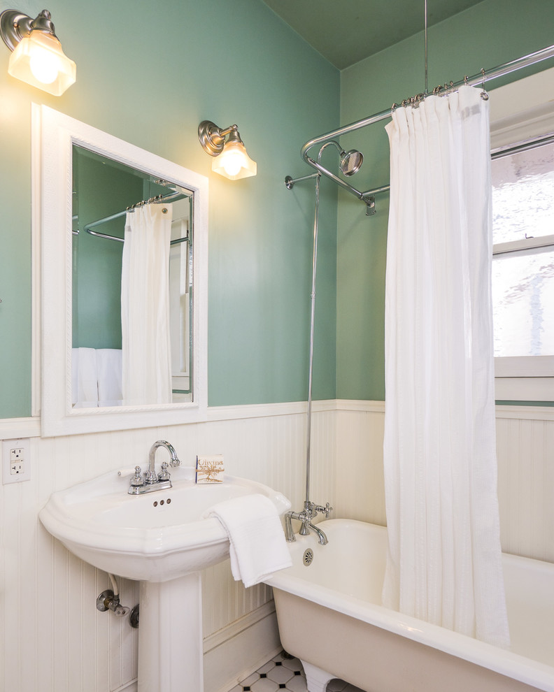 Стильный дизайн: ванная комната в классическом стиле с ванной на ножках, раковиной с пьедесталом и зелеными стенами - последний тренд