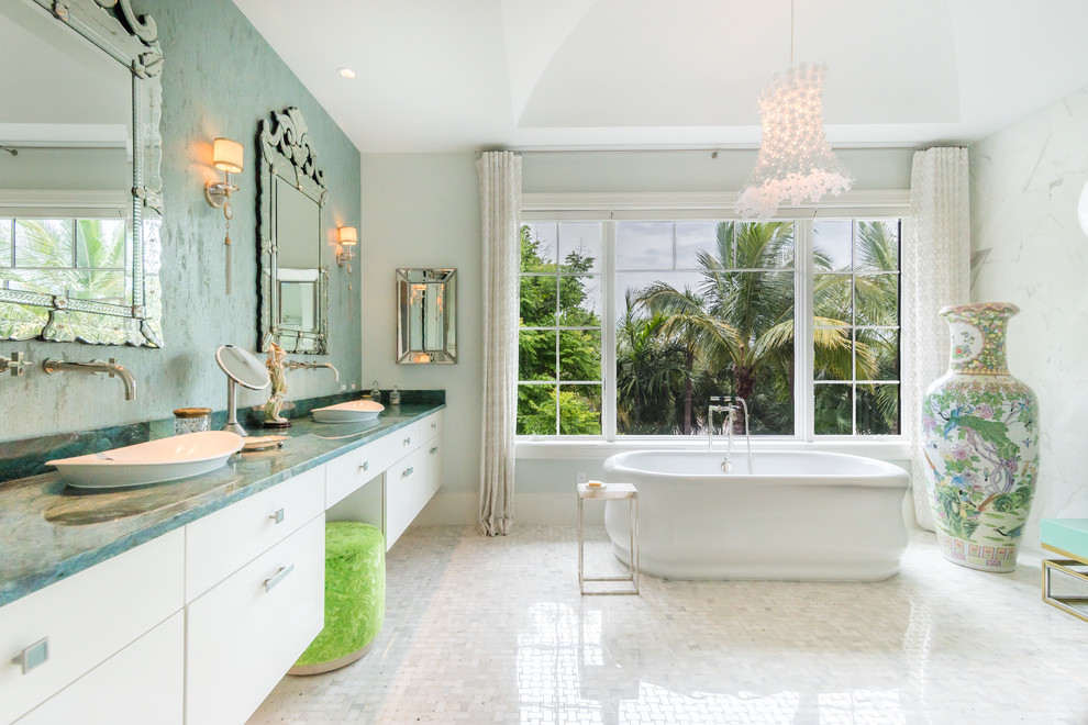 Exempel på ett exotiskt blå blått en-suite badrum, med släta luckor, vita skåp, ett fristående badkar, flerfärgade väggar, ett fristående handfat och vitt golv