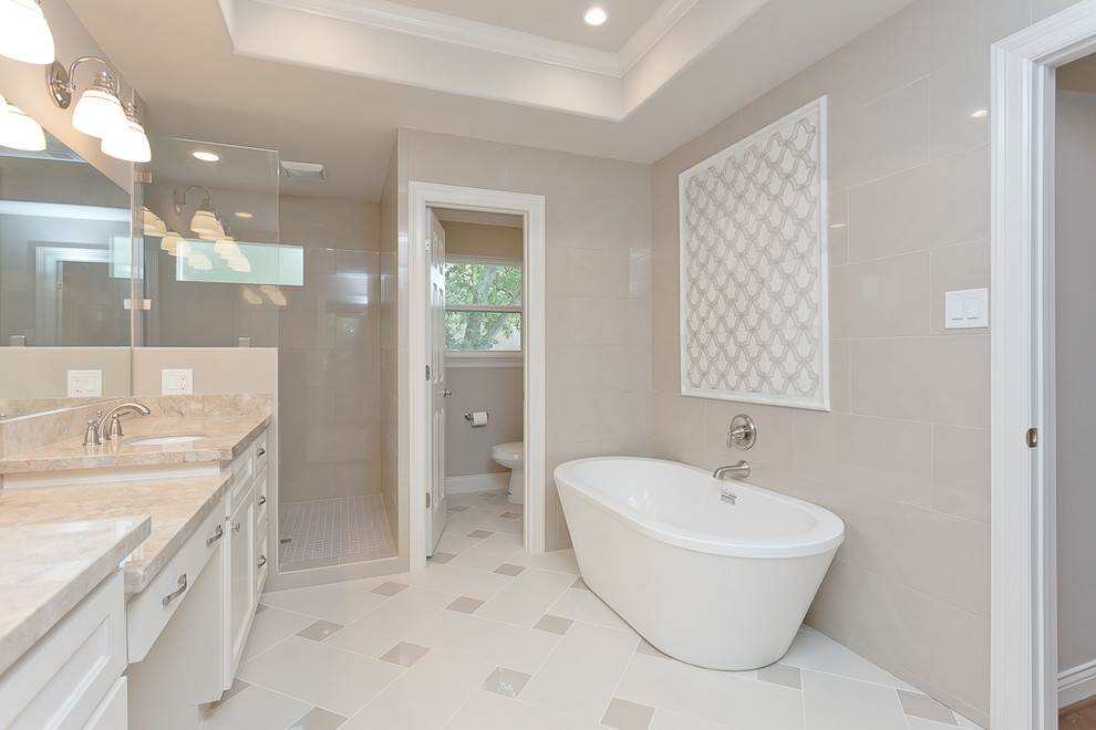 This is an example of a traditional bathroom in Houston with a submerged sink, shaker cabinets, white cabinets, a freestanding bath, a corner shower, a one-piece toilet, grey tiles, ceramic tiles, grey walls and ceramic flooring.