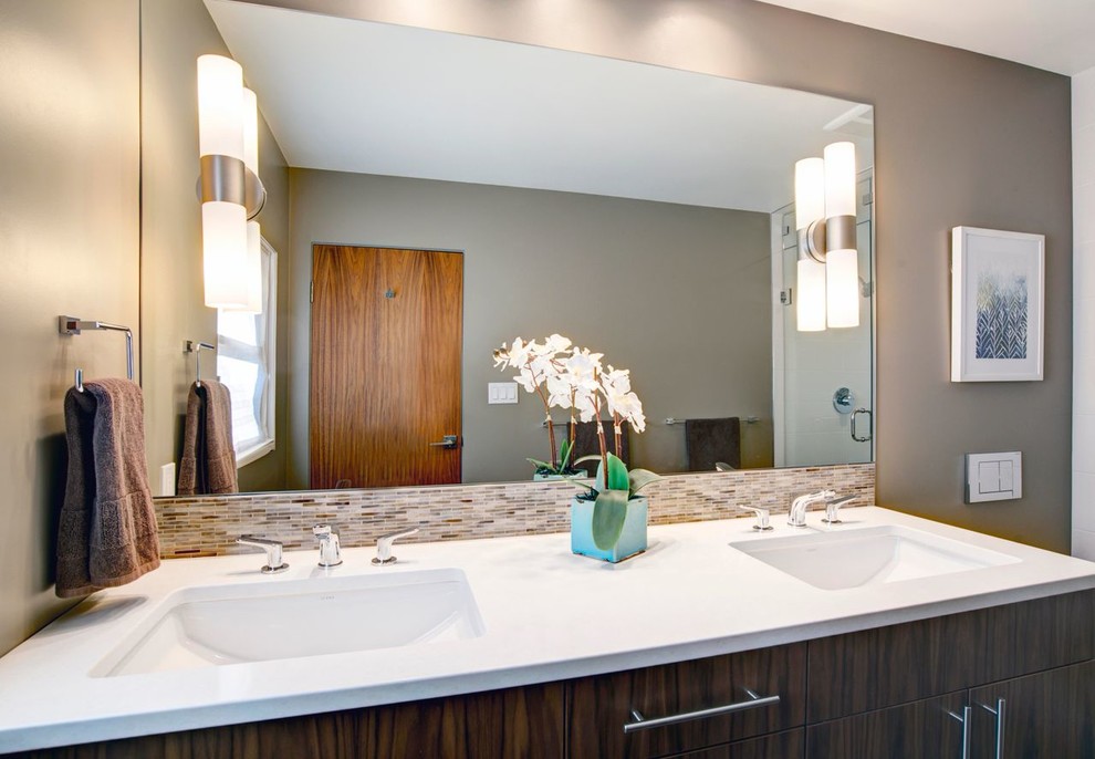 Klassisk inredning av ett mellanstort en-suite badrum, med ett konsol handfat, skåp i mellenmörkt trä, ett badkar i en alkov, en dusch/badkar-kombination, vit kakel, keramikplattor, vita väggar, släta luckor och träbänkskiva