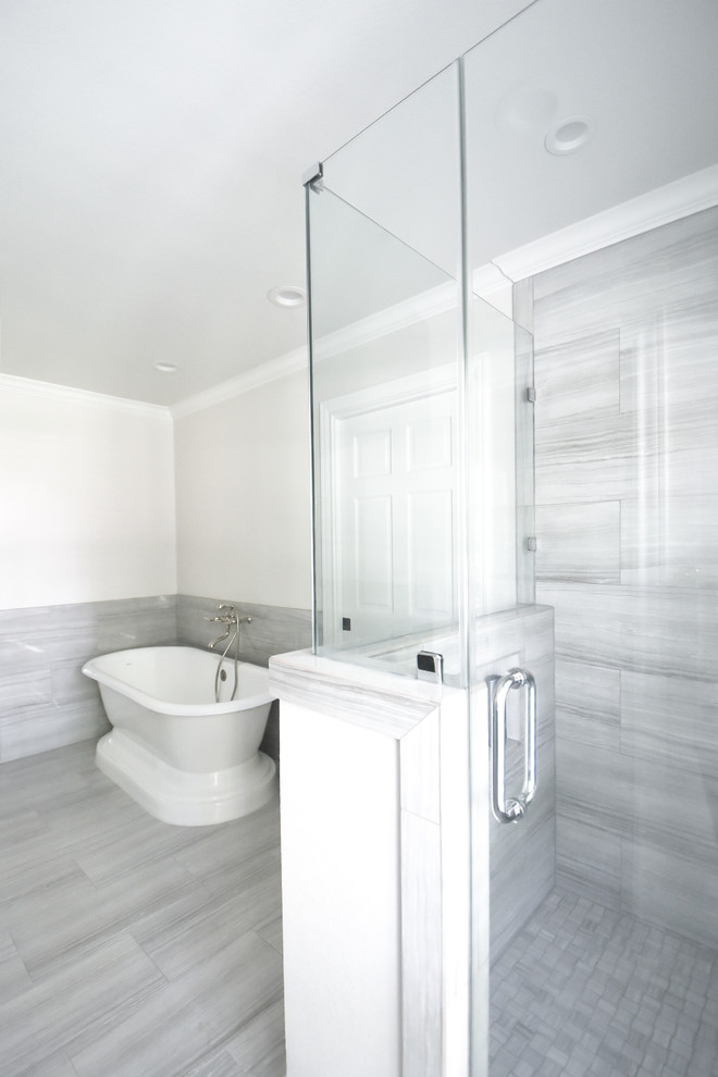 Inspiration for a large traditional ensuite bathroom in Houston with shaker cabinets, grey cabinets, a freestanding bath, a corner shower, a two-piece toilet, grey tiles, porcelain tiles, grey walls, porcelain flooring, a submerged sink, granite worktops and grey floors.
