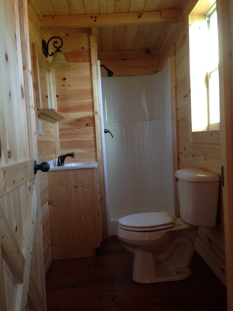 Inredning av ett amerikanskt litet badrum med dusch, med ett integrerad handfat, luckor med upphöjd panel, skåp i ljust trä, bänkskiva i akrylsten, en hörndusch, en toalettstol med hel cisternkåpa, beige väggar och mellanmörkt trägolv