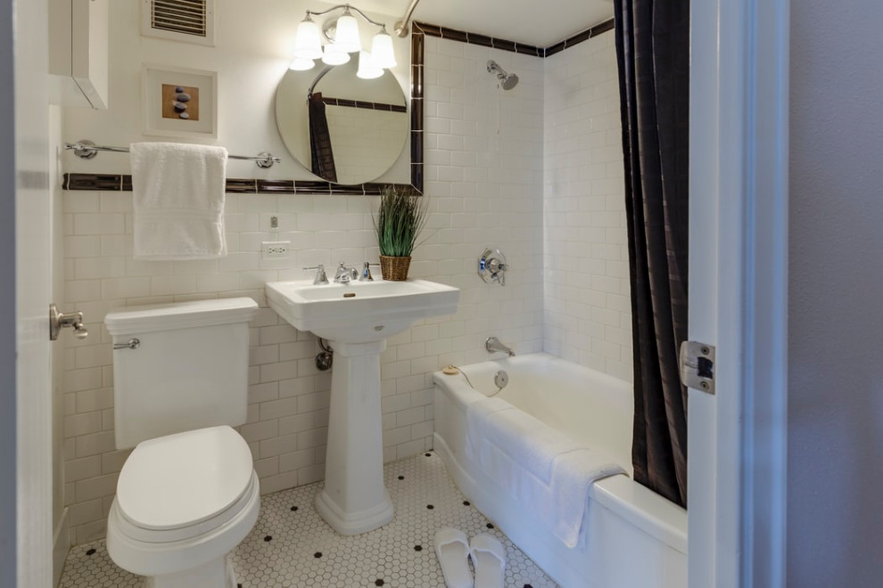 Стильный дизайн: маленькая главная ванная комната в стиле кантри с раздельным унитазом, плиткой из травертина, напольной тумбой, душем над ванной, черно-белой плиткой, белыми стенами, полом из мозаичной плитки, раковиной с пьедесталом, белым полом, шторкой для ванной, белой столешницей и тумбой под одну раковину для на участке и в саду - последний тренд