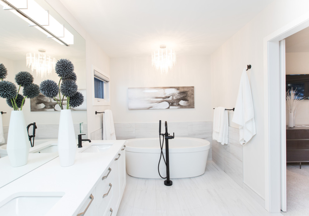 Idee per una grande stanza da bagno chic con ante in stile shaker, ante bianche, vasca freestanding, piastrelle grigie, pareti bianche, lavabo sottopiano, pavimento bianco e top bianco
