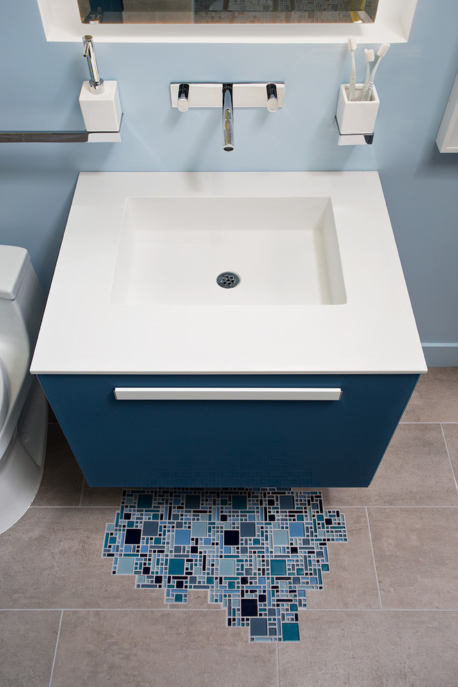 Small minimalist kids' blue tile and mosaic tile porcelain tile doorless shower photo in San Francisco with a wall-mount sink, furniture-like cabinets, solid surface countertops, a one-piece toilet and blue walls