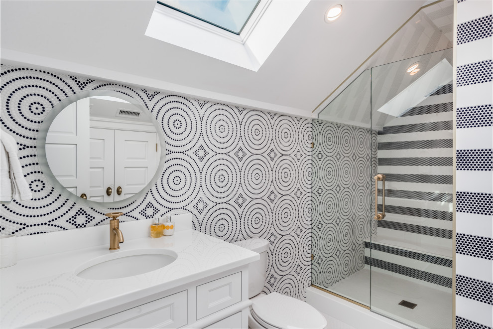 Photo of a traditional shower room bathroom in New York with recessed-panel cabinets, white cabinets, an alcove shower, a two-piece toilet, multi-coloured tiles, multi-coloured walls, a submerged sink, a hinged door and white worktops.