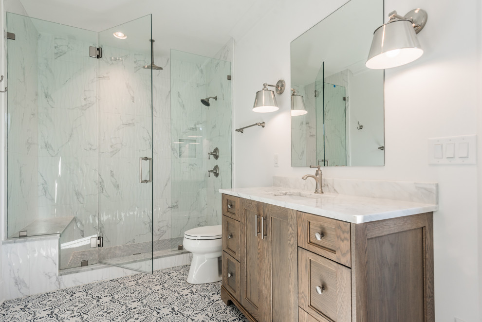 Inspiration for a mid-sized transitional 3/4 gray tile multicolored floor alcove shower remodel in Charlotte with shaker cabinets, light wood cabinets, white walls, an undermount sink, a hinged shower door and white countertops