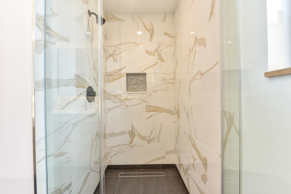 Пример оригинального дизайна: ванная комната среднего размера в стиле модернизм с фасадами островного типа, светлыми деревянными фасадами, отдельно стоящей ванной, открытым душем, унитазом-моноблоком, белой плиткой, керамогранитной плиткой, белыми стенами, полом из керамогранита, настольной раковиной, столешницей из гранита, серым полом, душем с распашными дверями и белой столешницей