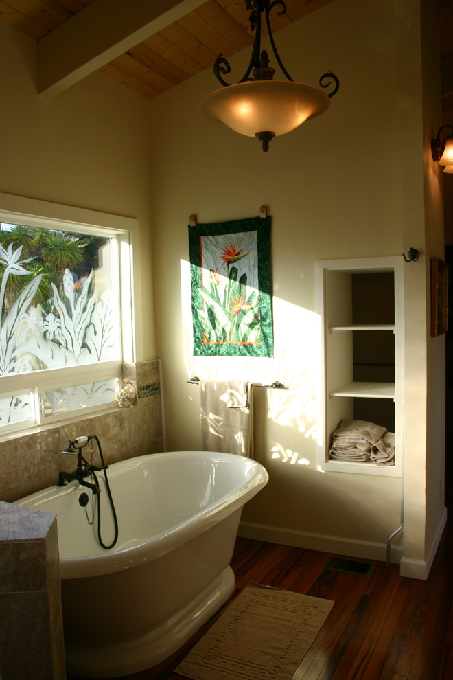 Example of a mid-sized arts and crafts master beige tile and stone tile medium tone wood floor freestanding bathtub design in San Luis Obispo with a pedestal sink, flat-panel cabinets, light wood cabinets, limestone countertops, a one-piece toilet and white walls
