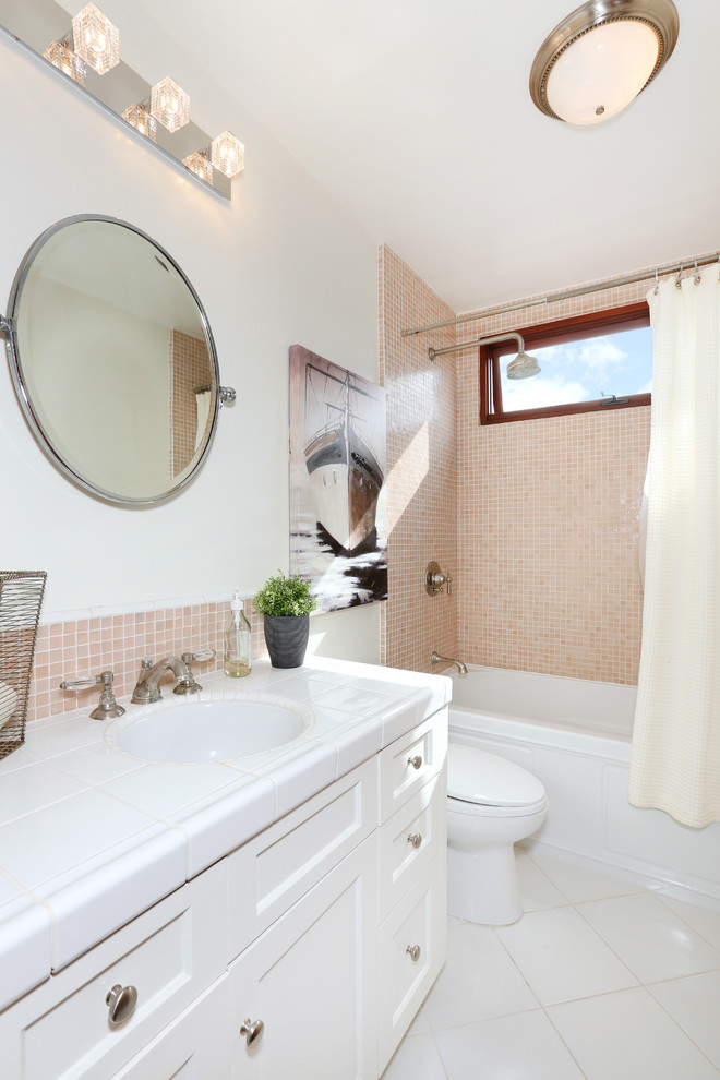 Foto di una stanza da bagno minimal con ante con riquadro incassato, top piastrellato, vasca da incasso, piastrelle in ceramica, pareti bianche e pavimento con piastrelle in ceramica