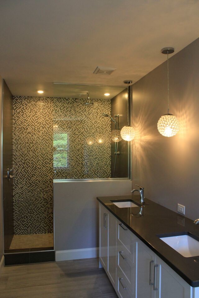 Cette image montre une grande douche en alcôve principale traditionnelle avec un lavabo encastré, un placard à porte shaker, des portes de placard grises, un plan de toilette en onyx, un carrelage multicolore, un mur gris et un sol en bois brun.