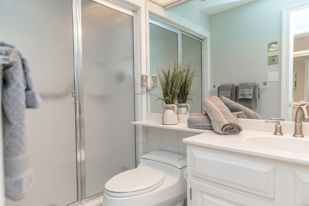 Exempel på ett mellanstort klassiskt vit vitt en-suite badrum, med luckor med upphöjd panel, vita skåp, ett badkar i en alkov, en dusch/badkar-kombination, bänkskiva i akrylsten och dusch med skjutdörr