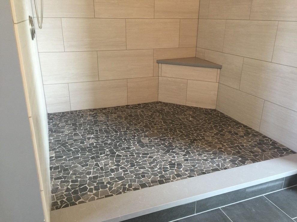 Modern inredning av ett badrum, med en öppen dusch, beige kakel, porslinskakel och klinkergolv i småsten